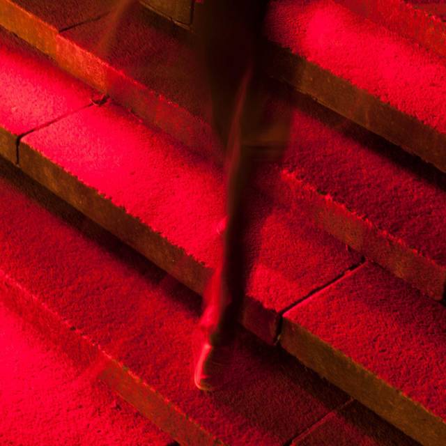 Männerbein in Anzug auf roter Treppe