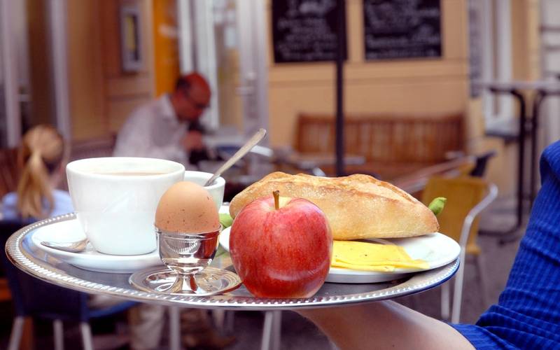 Frühstückstablett mit Kaffee, Brötchen, Apfel und Ei