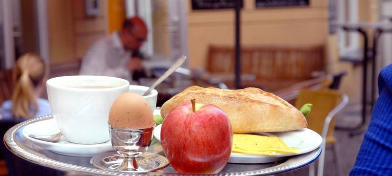 Frühstückstablett mit Kaffee, Brötchen, Apfel und Ei
