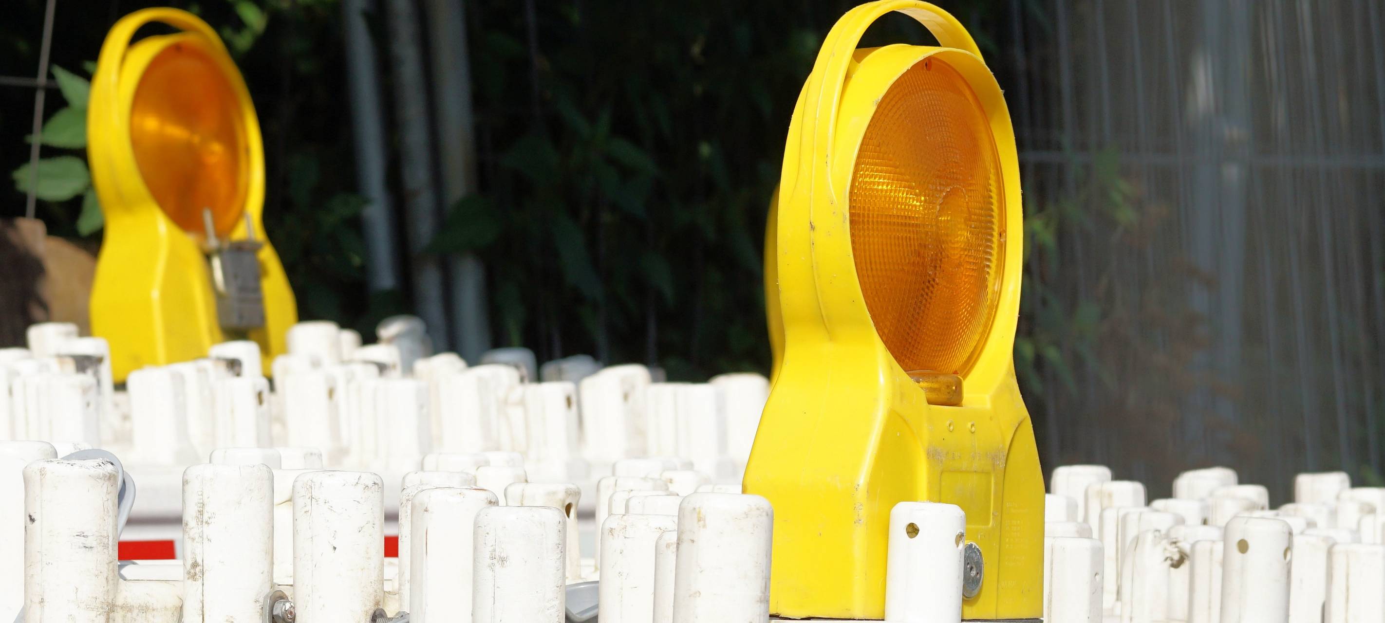 Hintereinander stehend gestapelte Absperrungen für Straßensperrungen mit zwei Lichtern.