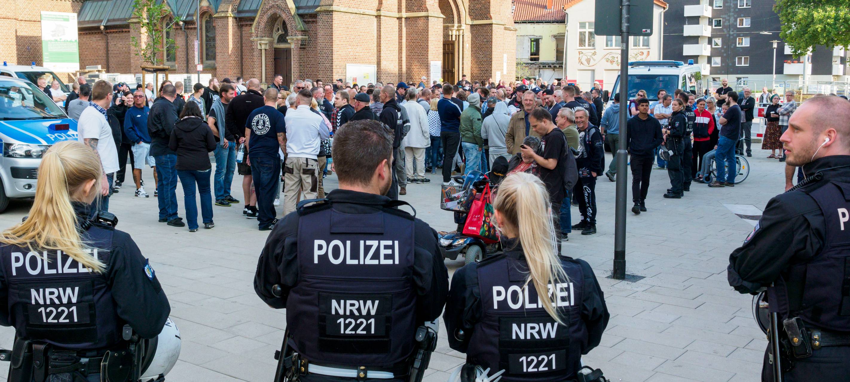 Rechts orientierte "besorgte Bürger" stehen am Dienstag, 20.08.2019, in Herne beobachtet von Polizisten vor der Kreuzkirche. Zwei "Spaziergänge" "besorgter Bürger" haben in diesem Sommer bereits in der Herner City stattgefunden, dabei sind die "besorgten Bürger" jeweils von der Kreuzkirche Richtung Bahnhof und zurück gegangen.