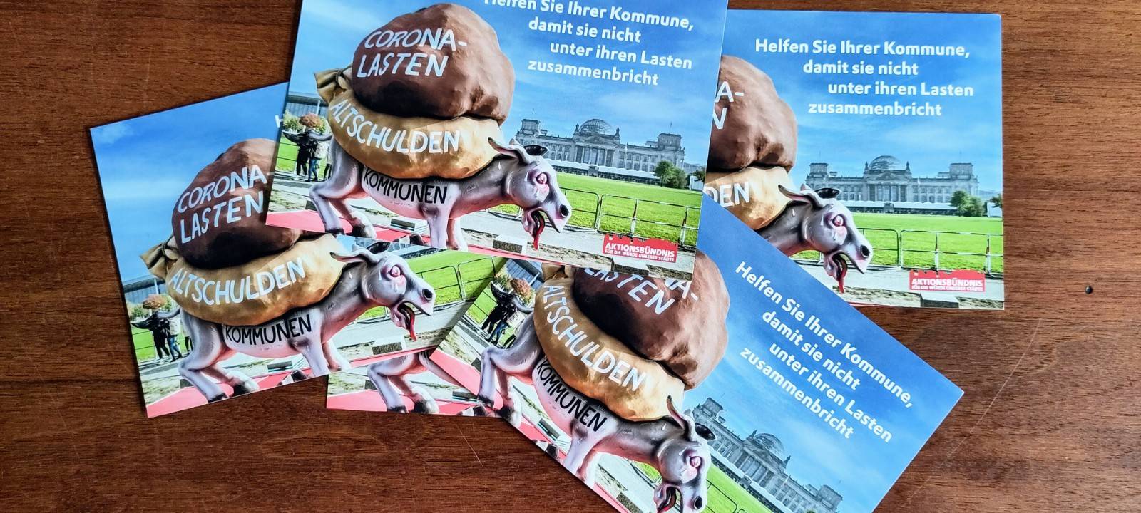 Mit einer Postkartenaktion erinnert das Bündnis "Für die Würde unserer Städte" an versprochene finanzielle Unterstützung.