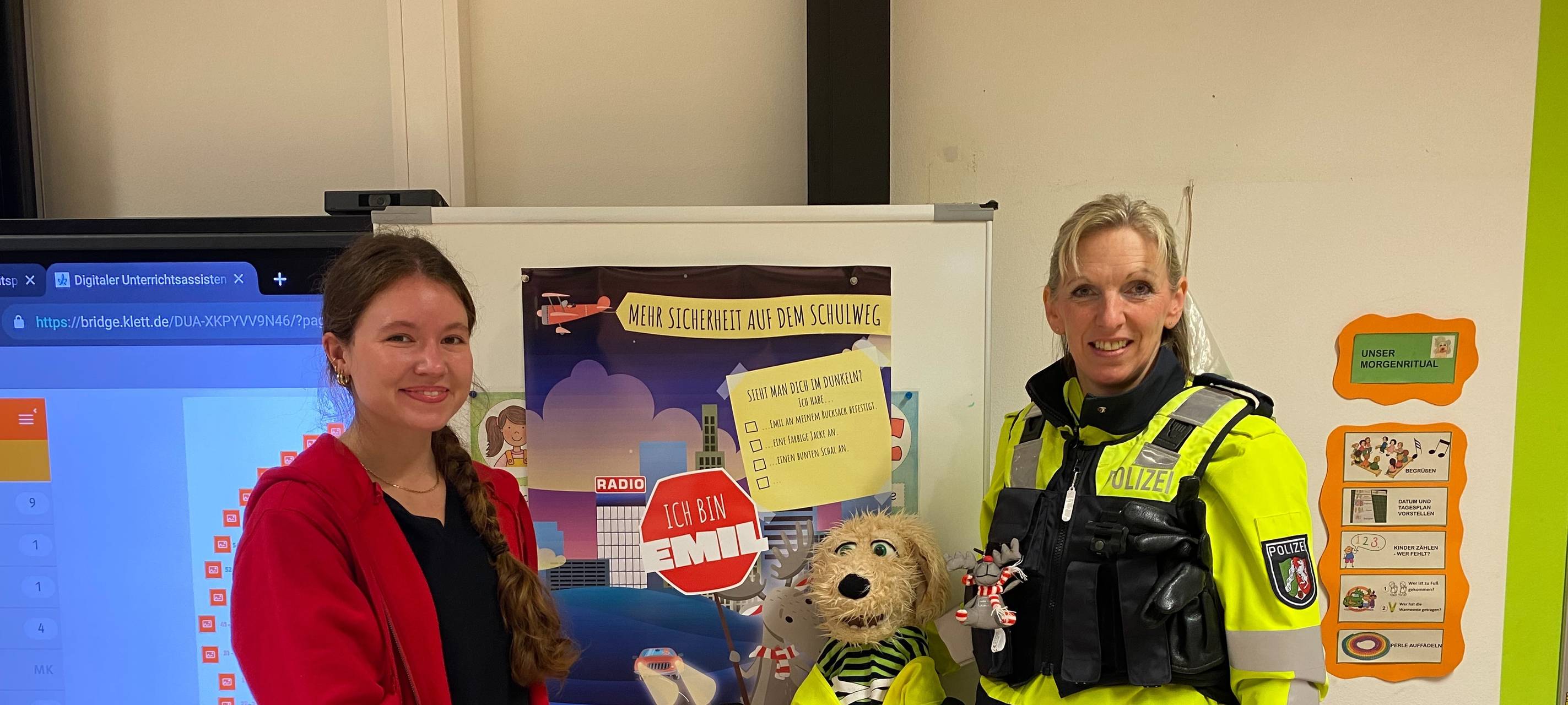 Eine Radioreporterin und eine Polizistin stehen mit einem Stofftier in einem Klassenraum. | Foto: Zoé Kozlowski / Radio Herne