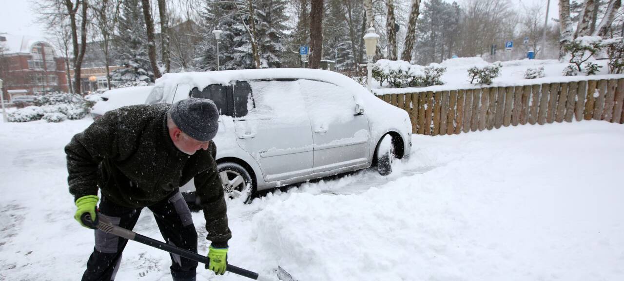 Hoteltechniker Thomas Paul räumt den Schnee in der Zufahrt zum Hotel in der Ortschaft Malente im Kreis Ostholstein.