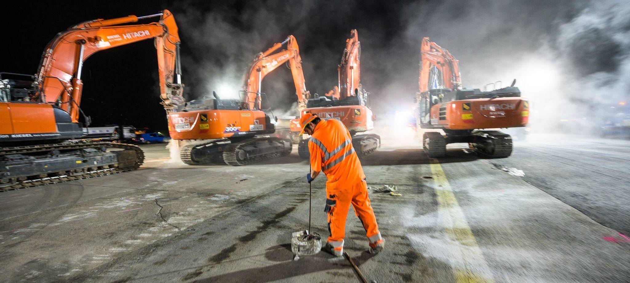 Bauarbeiter sanieren eine Rollbahn auf einem Flughafen