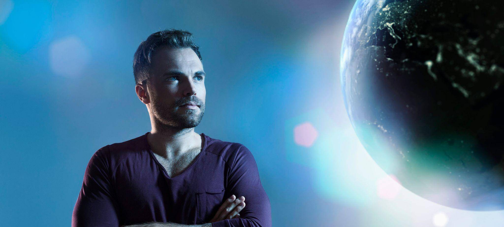 Mann schaut zu einer animierten Erdkugel