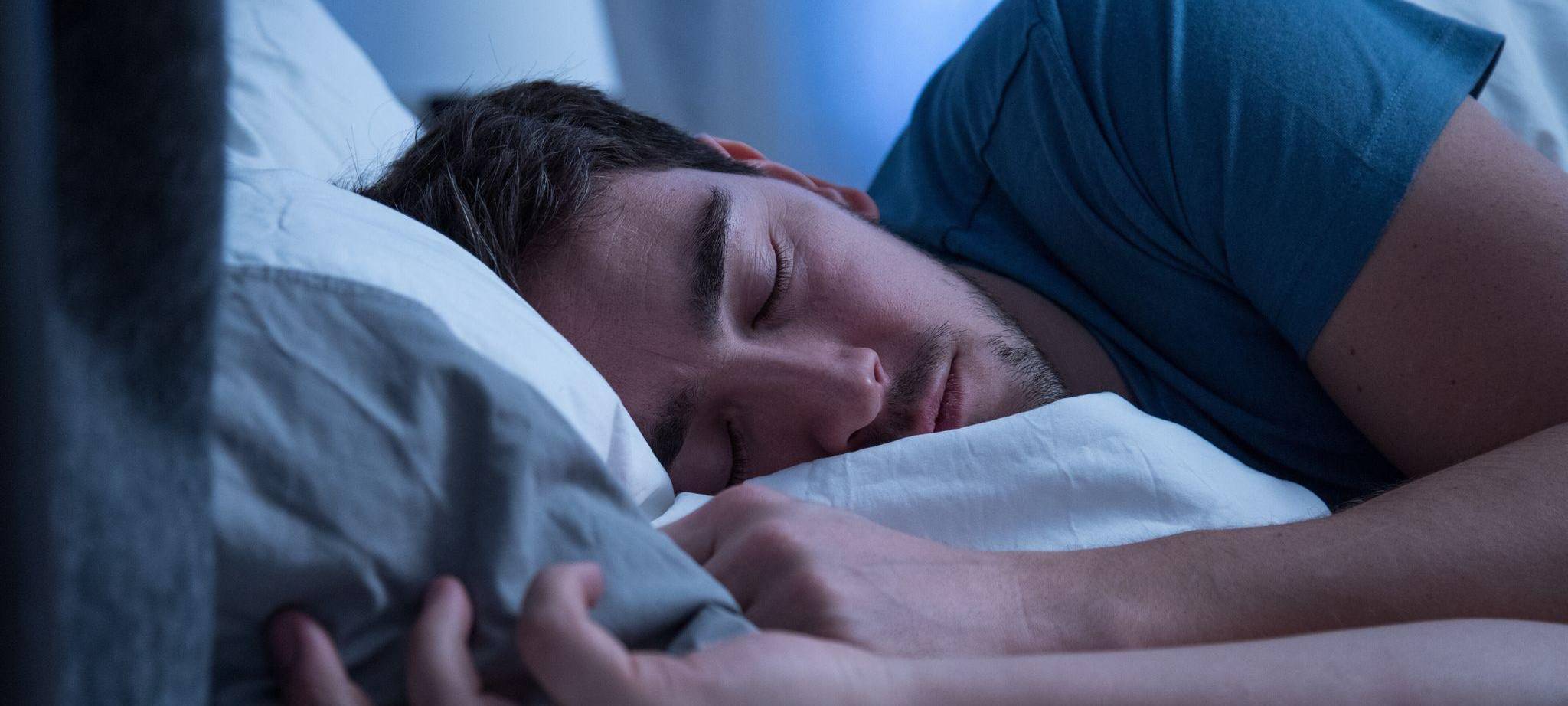 Mann schläft in einem Bett