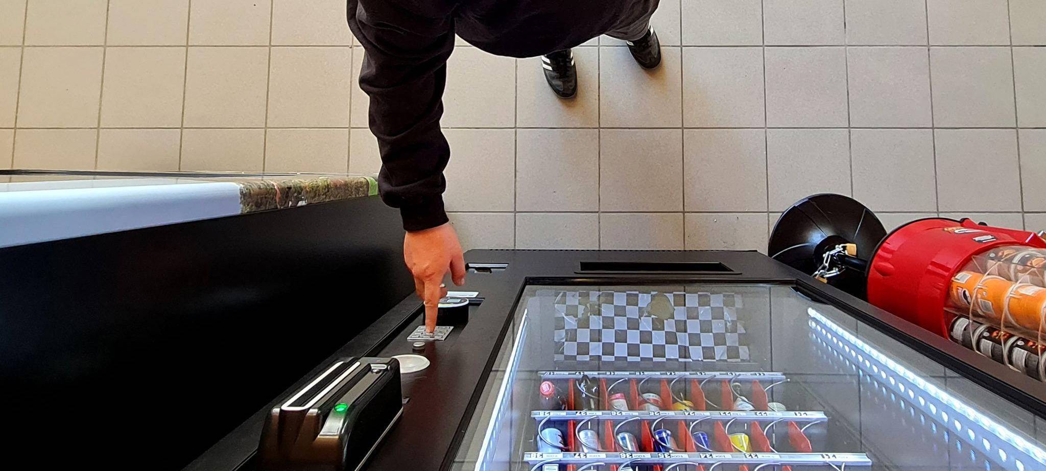 GEin Mann kauft etwas aus dem Automaten