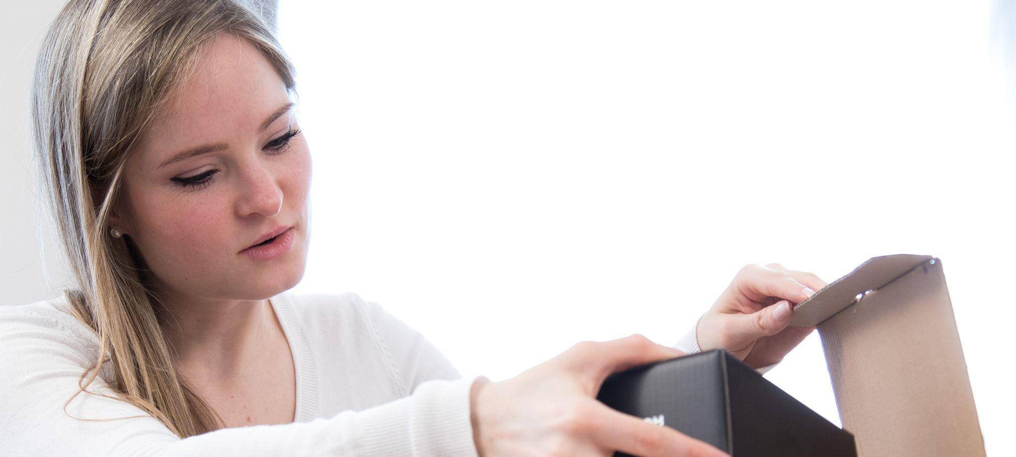 Eine Frau öffnet ein Paket