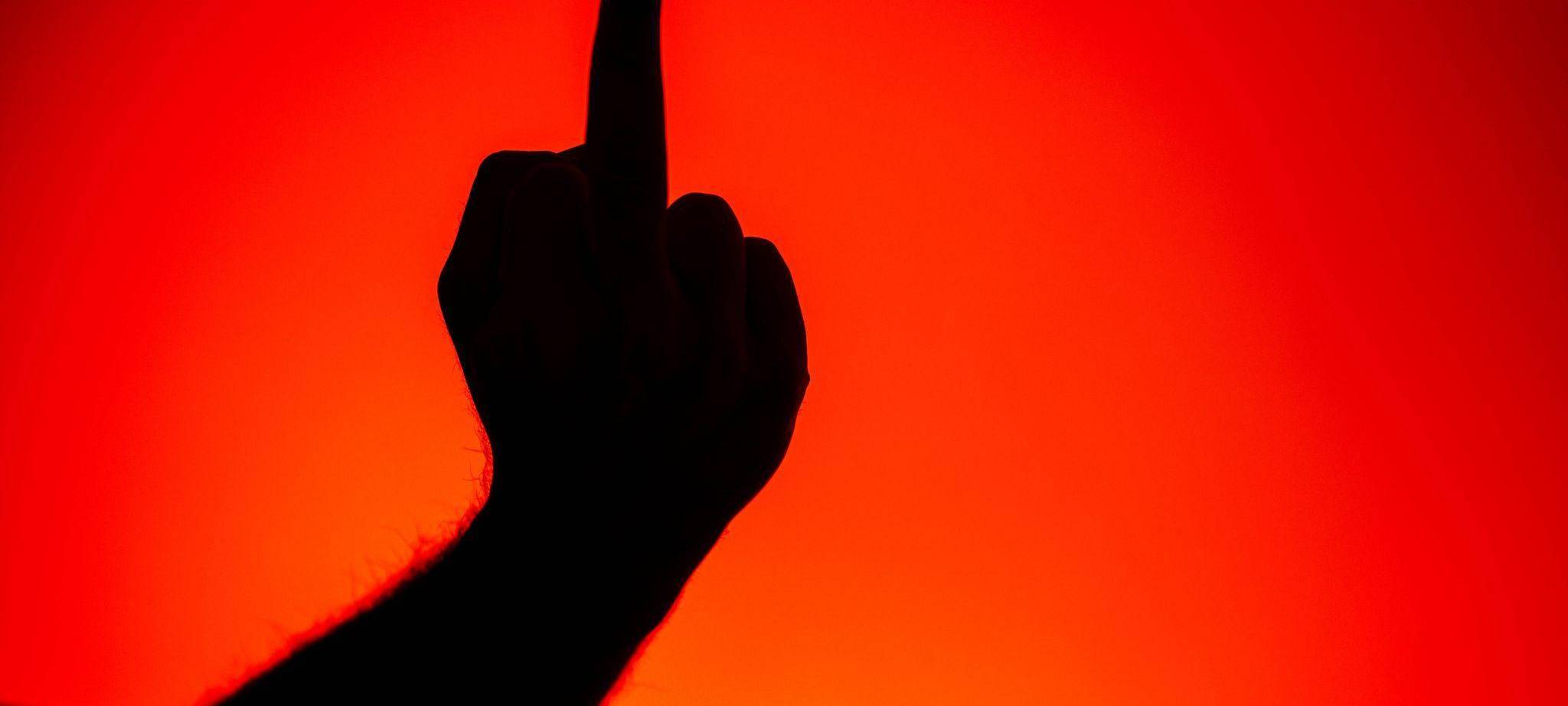 Eine Person zeigt den Mittelfinger